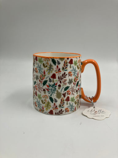 Ceramic mug with leaf pattern and orange handle on a white background